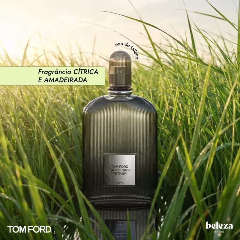Frasco de item de perfumaria da marca Tom Ford, com textura estriada e rótulo com texto "Eau de Grey Vetiver", em meio a gramíneas verdes.