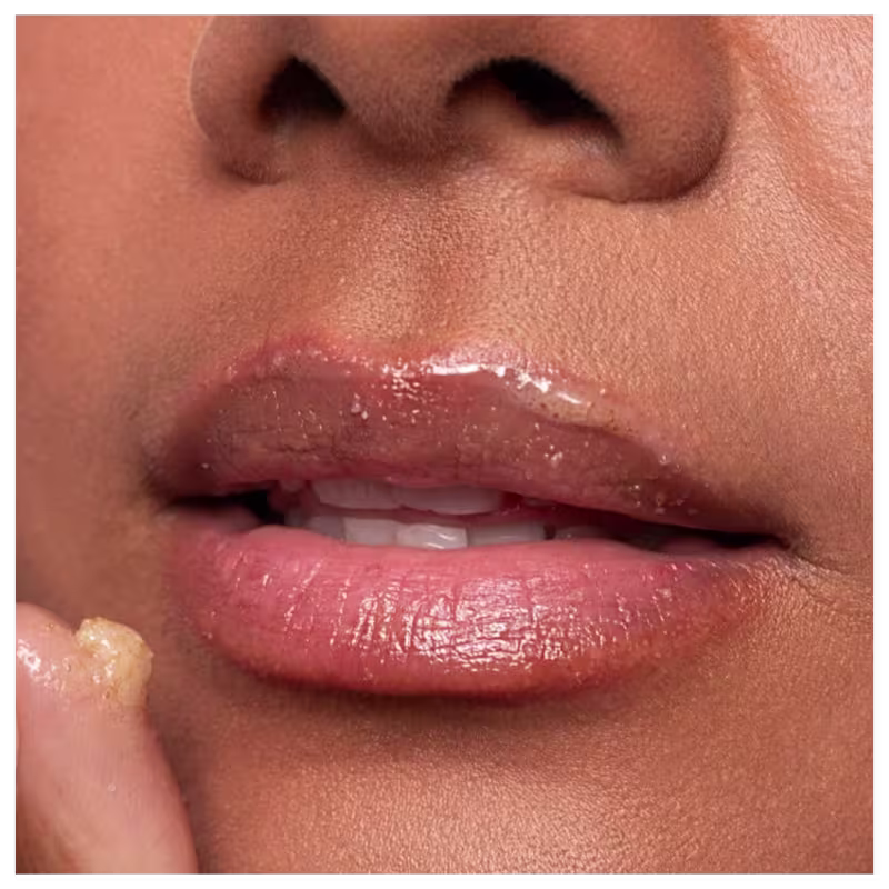 Imagem da boca de uma mulher negra logo após ter aplicado o esfoliante labial CARE Natural Beauty Silky Lips Rose Scrub.