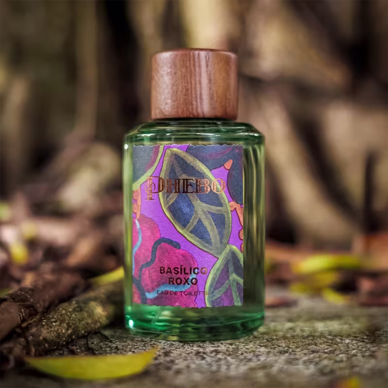 Frasco de item de perfumaria da marca Phebo, com rótulo roxo e amarelo, contendo ilustrações florais e texto "Basilic roxo" em destaque.