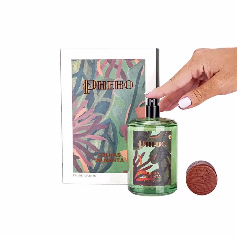 Frasco de item de perfumaria da marca Phebo com rótulo verde e laranja, apresentando folhas estilizadas em tons de verde, azul e rosa.