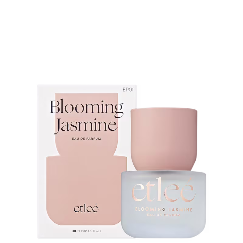 Frasco de perfume Etleé Blooming Jasmine, com caixa rosa clara e rótulo com o nome do produto em letras pretas. O frasco possui formato cilíndrico e tampa arredondada.