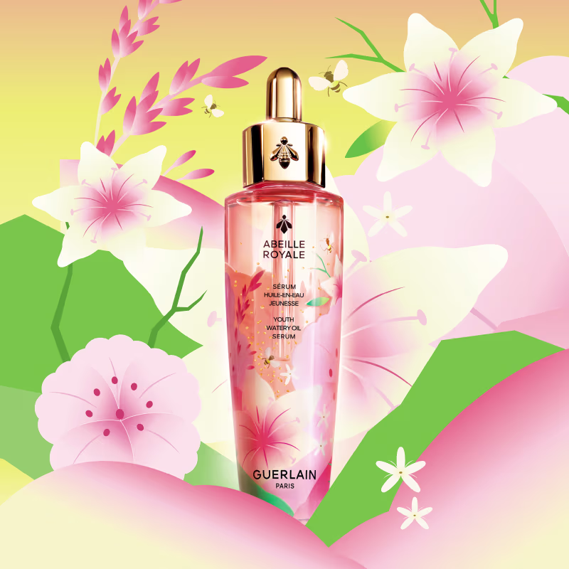 Frasco de vidro rosa com tampa dourada contendo o sérum Abeille Royale da Guerlain, com flores e abelhas ilustradas em fundo amarelo e verde.