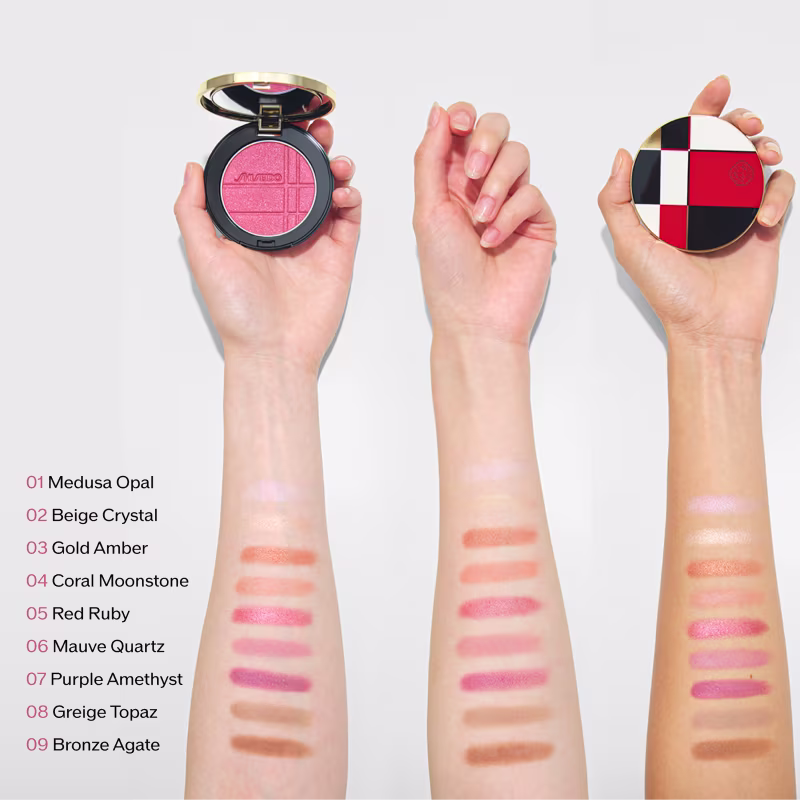 Compacto de blush em tons rosados com acabamento acetinado, exibido em mãos com diferentes tons de pele, junto a outros itens de perfumaria com design geométrico.