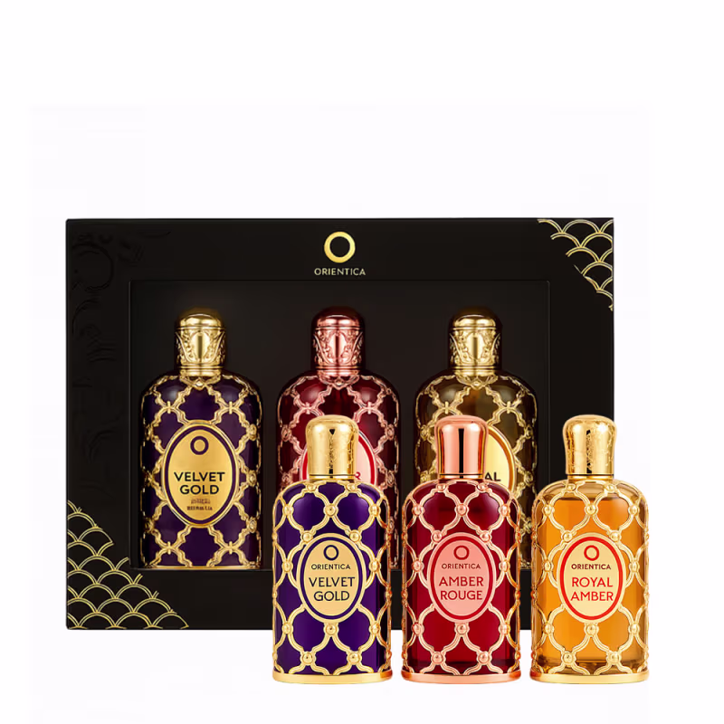 Conjunto de três frascos de perfumes Orientica, com embalagens decoradas em preto, dourado e vermelho, exibindo os nomes "Velvet Gold", "Amber Rouge" e "Royal Amber".