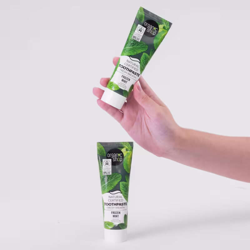 A imagem mostra o tubo da pasta de dente e uma mão segurando outro tubo.