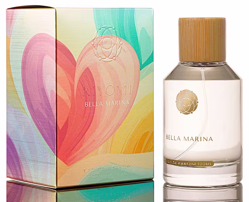 Perfume Bella Marina da marca KIYOMI em frasco de vidro com tampa de madeira, embalado em caixa colorida com ilustrações abstratas em tons de rosa, laranja e azul.