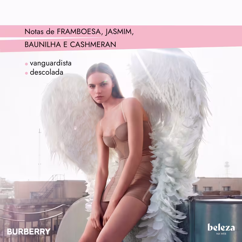 Uma mulher de cabelos escuros usa um conjunto de lingerie bege e asas brancas de plumas.