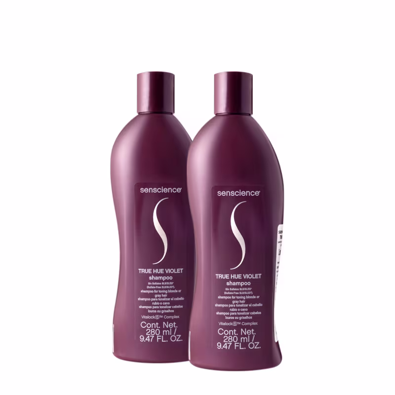 Dois frascos de shampoo Senscience True Hue Violet, com embalagens de plástico de cor roxa escura, contendo 280 ml cada. Os rótulos exibem o nome da marca e a descrição do produto como shampoo para cabelos loiros ou grisalhos.