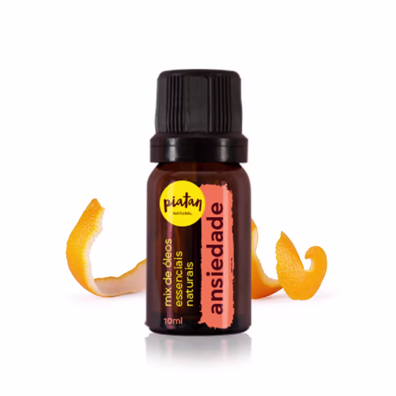 Frasco de óleo essencial natural Piatan de 10ml. Embalagem âmbar de vidro com tampa preta rosqueada. Rótulo laranja e amarelo com o nome do produto "ansiedade" e a marca Piatan. Cascas de laranja estilizadas ao redor do frasco.