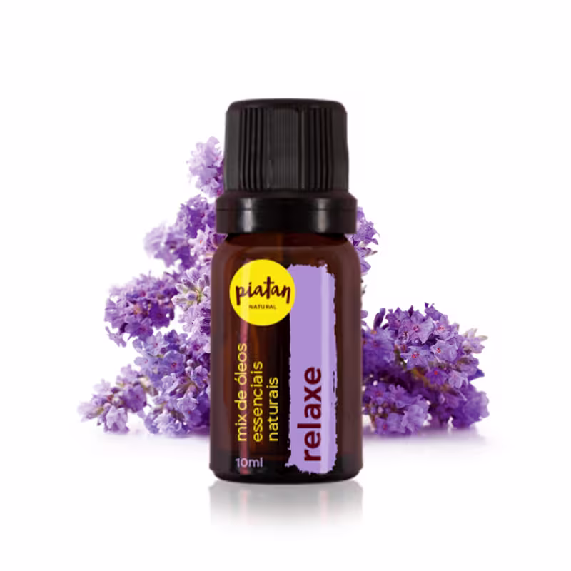 Frasco de óleo essencial de lavanda da marca Piatan. Frasco âmbar de 10ml com tampa preta rosqueada. Rótulo lilás com o nome "Relaxe". O frasco está cercado por flores de lavanda desabrochadas em tons de roxo e lilás.
