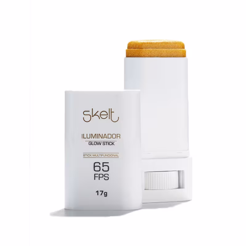 O produto é um Iluminador Glow Stick da marca Skelt, em embalagem branca com detalhes dourados, contendo informações sobre o fator de proteção solar 65 FPS e o peso líquido de 17g.