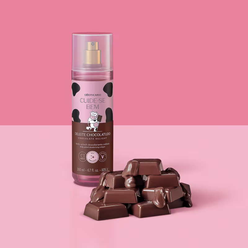 Produto de cuidados pessoais com fragrância de chocolate. Marca "Cuide-se Bem" e "Deleite Chocolatudo". Pedaços de chocolate ao leite espalhados ao lado do frasco, representando o aroma do produto. Embalagem de 200ml. Imagem com fundo rosa claro.