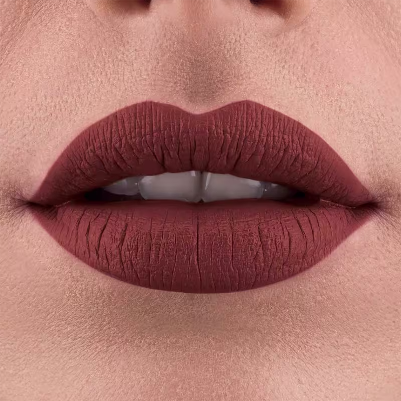 Imagem de close-up de lábios femininos com batom vermelho-escuro, em um ambiente que sugere um contexto de maquiagem e beleza da marca Make B.
