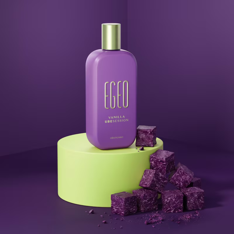 Frasco de item de perfumaria da marca Egeo em tom lilás, com rótulo dourado, sobre pedestal verde-limão, com cubos de cristal roxo ao redor em cenário monocromático roxo.