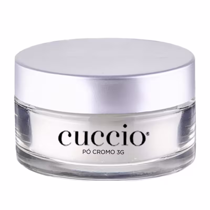 O produto apresentado é um pó cromo 3G da marca Cuccio. A embalagem é um recipiente circular de vidro transparente com uma tampa prateada. O rótulo do produto exibe claramente o nome "Cuccio" em letras pretas.