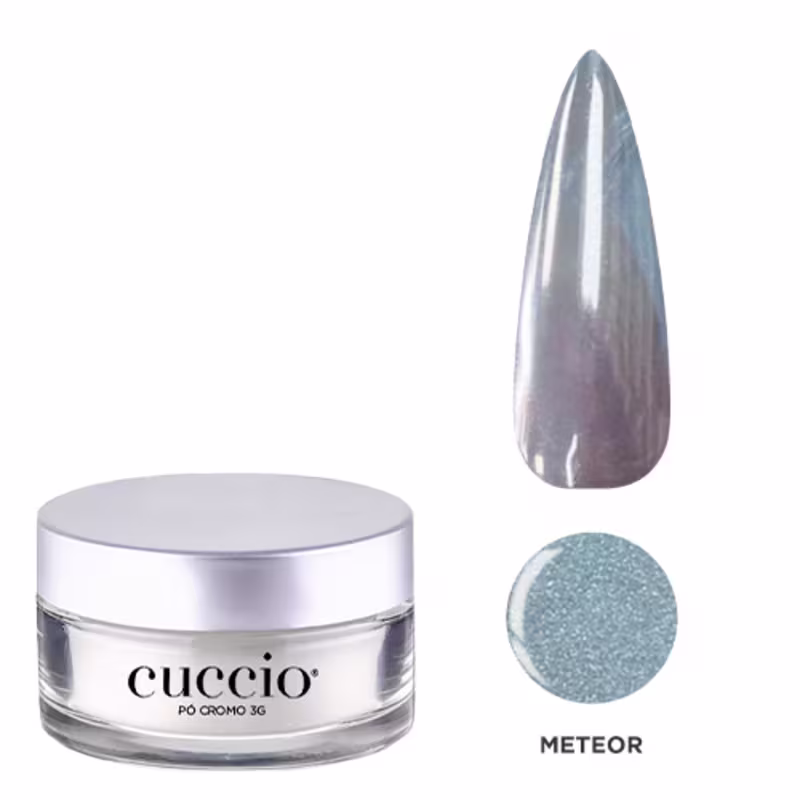 O produto apresentado é um pó da marca Cuccio Brasil, na cor Meteor. O produto está acondicionado em um recipiente de vidro com tampa prateada, exibindo o nome da marca em destaque. Ao lado, há uma imagem de uma ponta de unha na mesma tonalidade prateada.