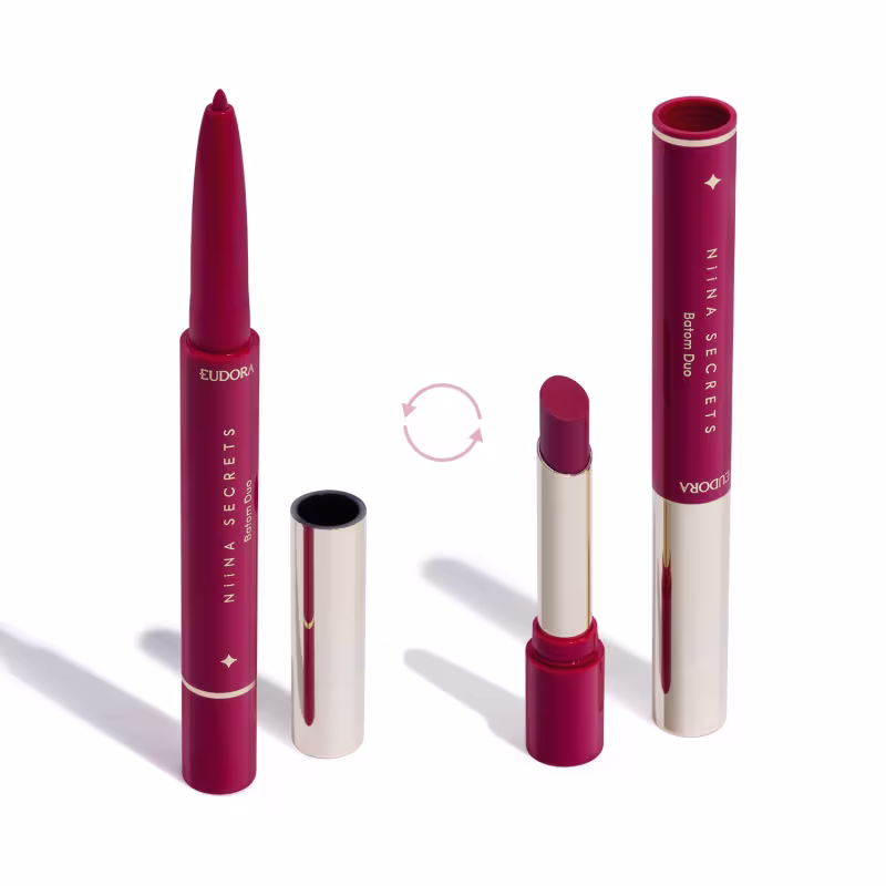 O produto apresentado na imagem é um batom da marca Niina Secrets Eudora. São dois produtos em um: uma lapiseira delineadora com a ponta afiada e o batom em formato stick. Todos os itens possuem detalhes em dourado e rosa.