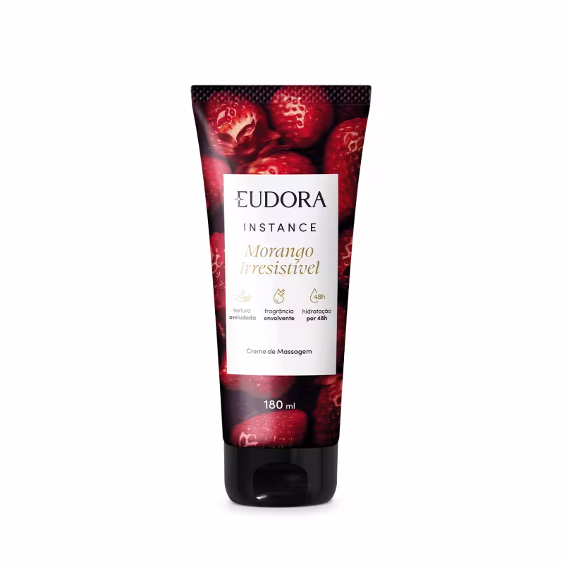 O produto apresentado é um creme de massagem da linha Instance da marca Eudora. A embalagem é um tubo plástico vermelho com uma imagem de morangos em destaque. O rótulo contém o nome do produto "Morango Irresistível".