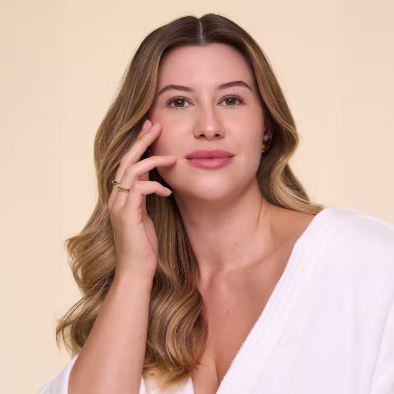 A imagem mostra a influenciadora Niina Secrets, com cabelos loiros longos e ondulados e pele radiante, sugerindo cuidado de skincare
