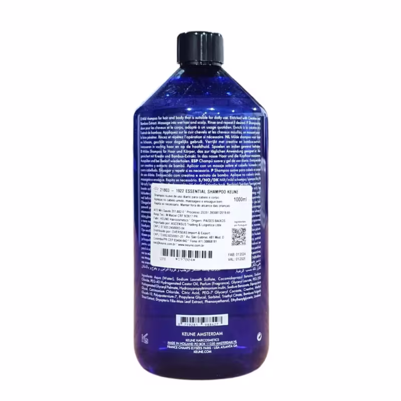 A imagem mostra um shampoo essencial da marca Keune, destinado ao público masculino. O frasco é de plástico azul escuro transparente com detalhes em branco e preto, com capacidade de 1000 ml ou 33,8 fl oz.