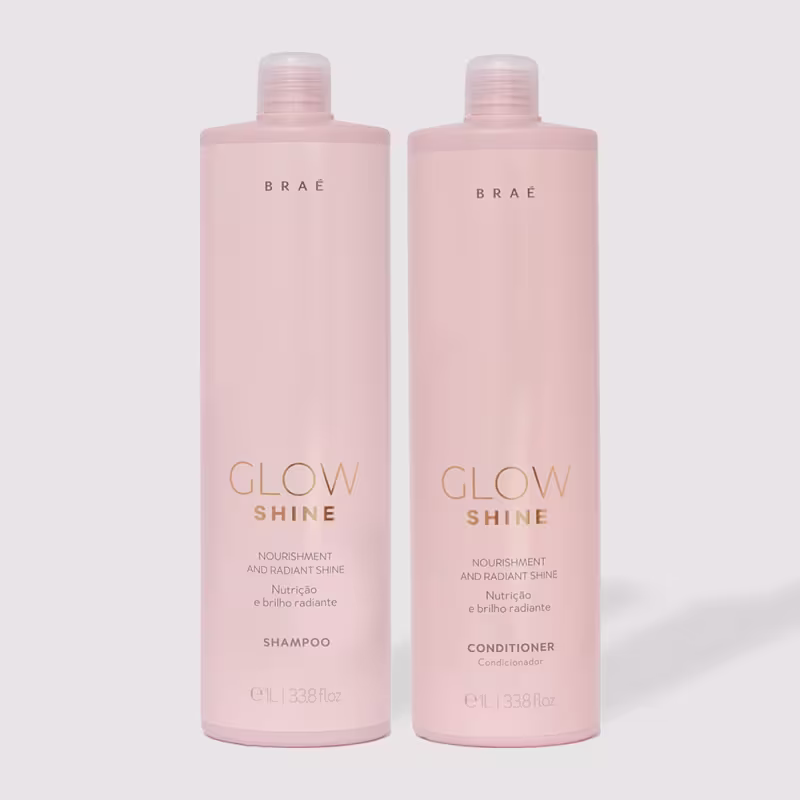 A imagem mostra dois frascos rosa claro contendo shampoo e condicionador da linha Glow Shine da marca Brae. Nas embalagens, está impresso em letras douradas "Glow Shine - Nourishment and Radiant Shine" (Nutrição e Brilho Radiante)