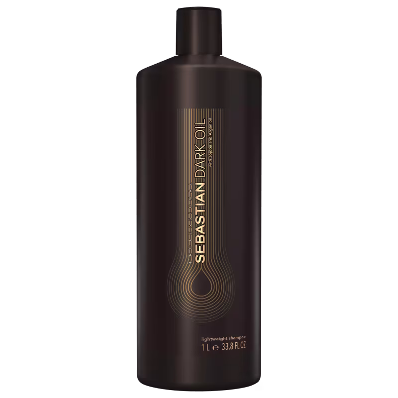 Shampoo leve da marca Sebastian Professional. Embalagem plástica marrom escura opaca com detalhes em dourado. Rótulo com o nome da marca e do produto "Sebastian Dark Oil" em letras douradas e estilizadas.