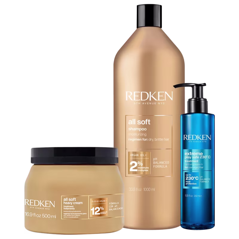 Produtos Redken incluem um frasco de shampoo All Soft, um pote de creme All Soft Heavy e um frasco do tratamento Extreme Play Safe 230°C, todos com embalagens em tons de dourado e azul.