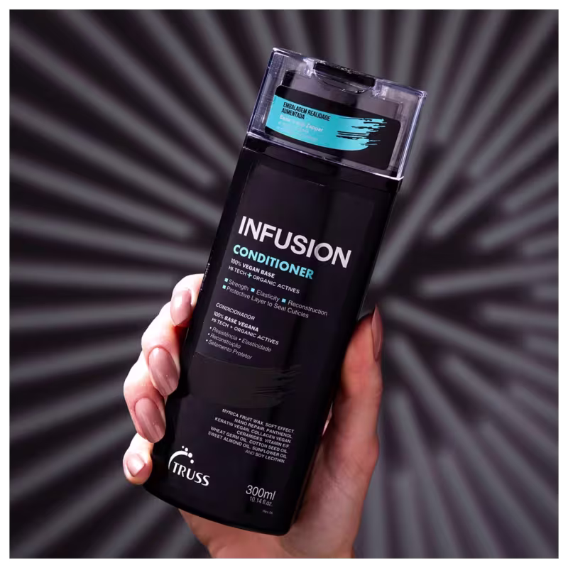 A imagem mostra uma mão feminina segurando o condicionador "Infusion" da marca Truss. É um produto apresentado em um frasco preto opaco com detalhes em azul. O rótulo informa que ele fortalece, dá elasticidade e reparação protetora aos fios.