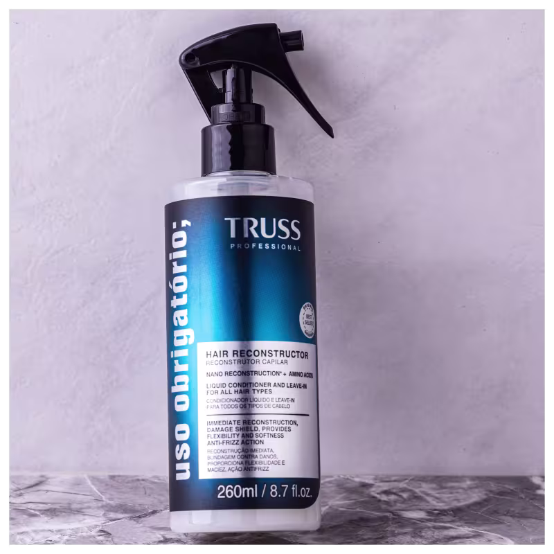 Produto de reconstrução capilar TRUSS Professional. Embalagem plástica transparente com spray acionado por bomba. Cor predominante azul escuro na parte central com detalhes em branco.