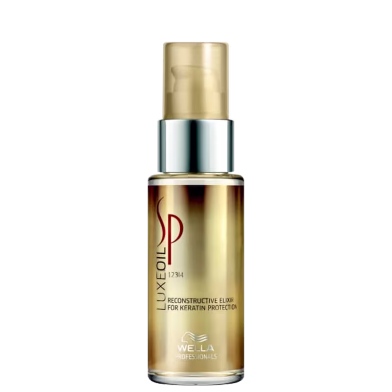 Produto de tratamento capilar da linha Luxe Oil da marca Wella Professionals. Frasco cilíndrico de vidro transparente com tampa dourada fosca. Rótulo dourado com o logotipo da marca.