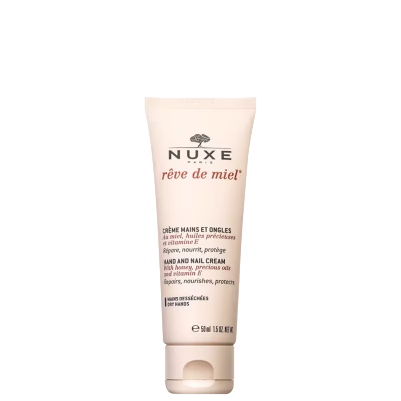 Creme para mãos e unhas da marca Nuxe, linha Rêve de Miel. Embalagem tubular bege com detalhes do rótulo em preto e vermelho. Formulado com mel, óleos preciosos e vitamina E, para reparar, nutrir e proteger as mãos ressecadas.