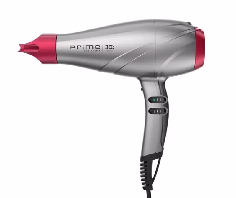 A imagem traz o secador de cabelo da GA.MA Italy Prime 3D Titanio. O acessório possui um corpo alongado e aerodinâmico em plástico cinza e detalhes em vermelho com o bico concentrador de ar removível na ponta.