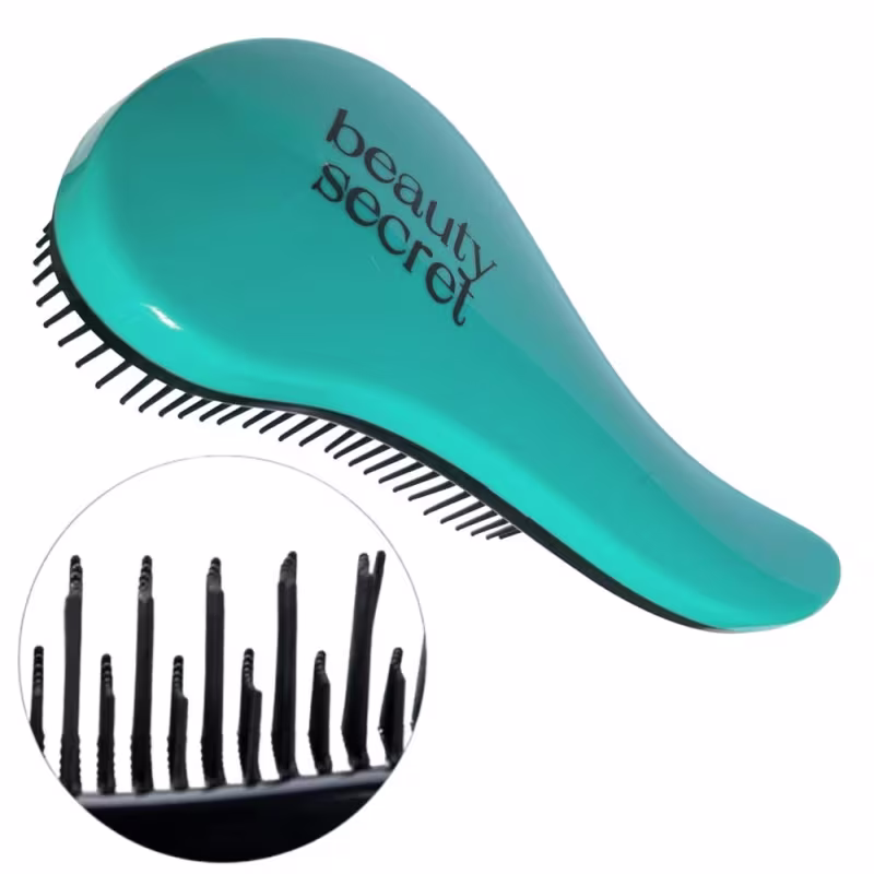 Escova de cabelo de plástico na cor turquesa. Tem um formato alongado com cerdas pretas em um lado. O nome "beauty secret" está impresso na superfície da escova em letras pretas. A imagem também mostra um detalhe ampliado das cerdas pretas da escova.