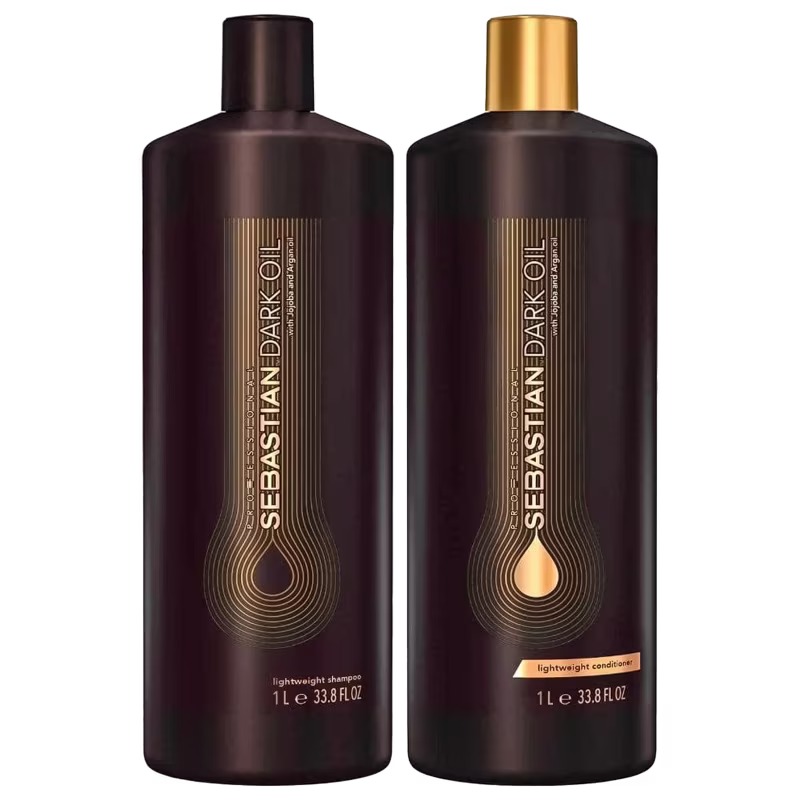 Shampoo e condicionador Dark Oil da marca Sebastian Professional. Os frascos são cilíndricos e escuros, com detalhes em dourado. Apresentam o logotipo e nome da marca "Sebastian Dark Oil" em letras douradas estilizadas.