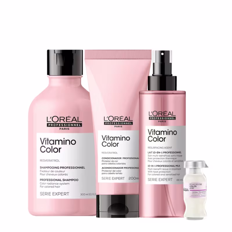 A imagem mostra a linha Vitamino Color da L’Oréal Professionnel, para cabelos coloridos, inclui shampoo (300ml), condicionador (200ml) e leave-in (190ml) em embalagens rosa e tampa preta. Completa o conjunto uma ampola embalagem branca e tampa prata.