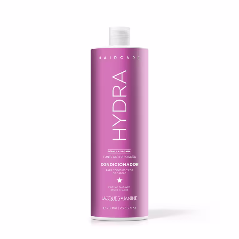 Frasco de condicionador da linha Haircare da marca Jacques Janine Professionnel, com embalagem rosa e branca, apresentando a fórmula vegana e a indicação de ser para todos os tipos de cabelo.