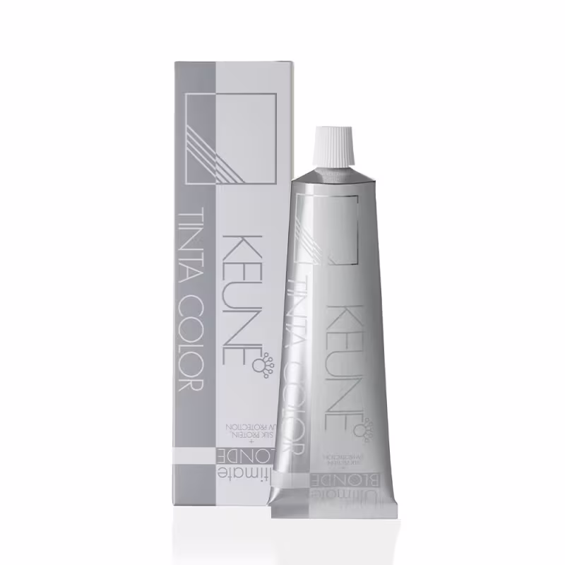 Produto de coloração capilar Keune Tinta Color. Embalagem composta por um tubo metálico prateado contendo o produto e uma caixa externa de papelão na cor cinza.