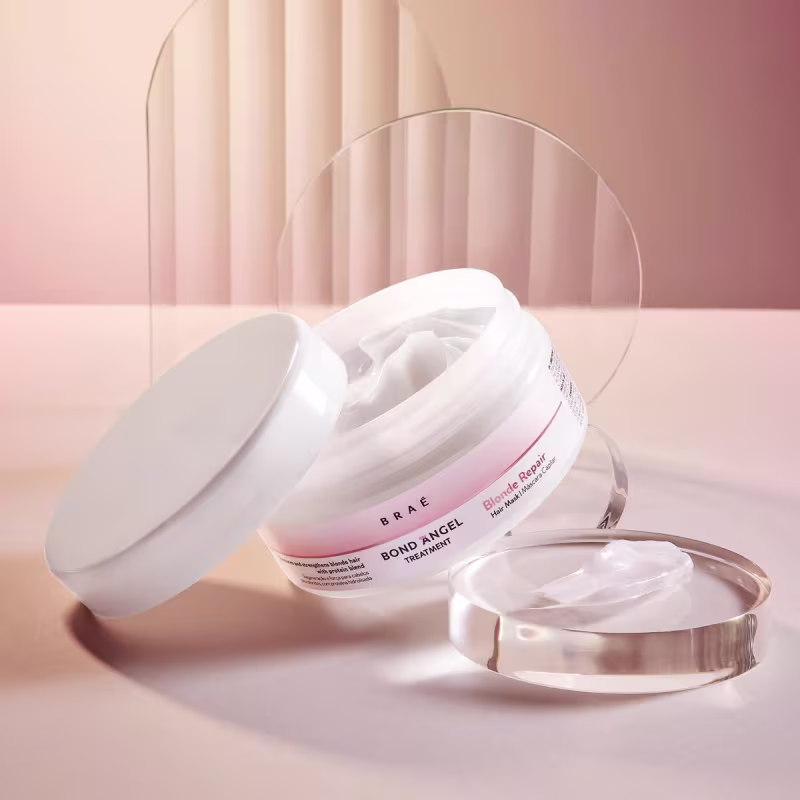 Tratamento Bond Angel da marca Braé. Embalagem em pote plástico branco com tampa removível. Rótulo rosa com o nome do produto e instruções em letras brancas.
