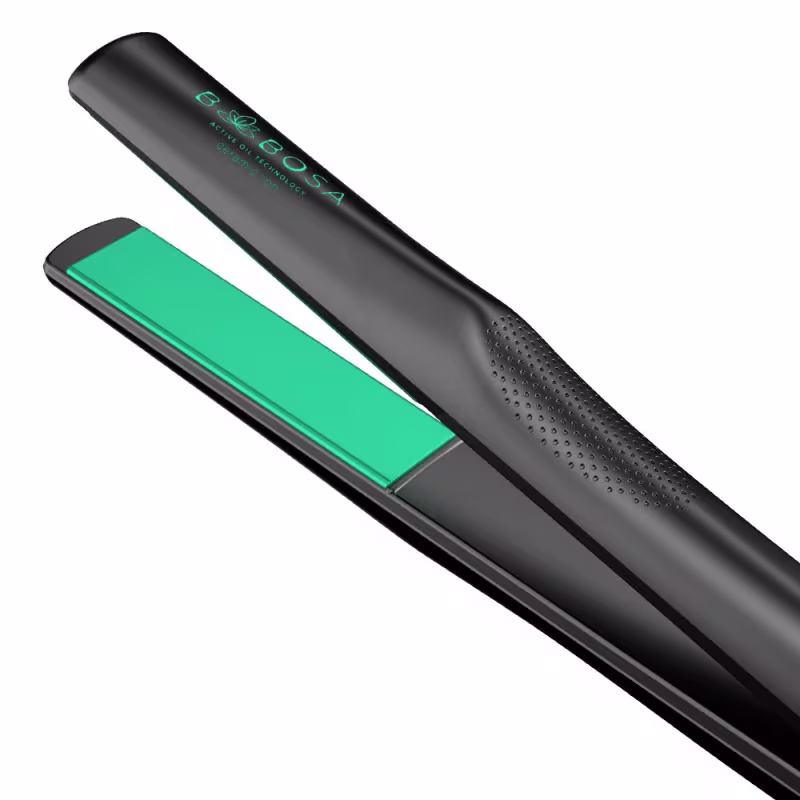 A imagem mostra uma chapinha com design alongado e cilíndrico, com um corpo preto fosco e detalhes em verde esmeralda. O modelador apresenta um formato ergonômico e linhas modernas.