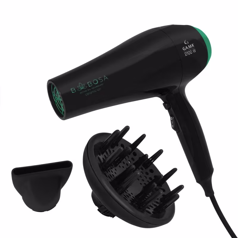 A imagem mostra um secador de cabelo profissional da marca GA.MA Italy. Ele possui um corpo cilíndrico preto com detalhes em verde escuro. Acompanha um difusor removível preto com pinos para modelar o cabelo e um bico de ar na cor preta.
