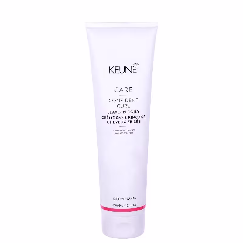 O produto apresentado é um creme leave-in da linha Confident Curl da marca Keune. A embalagem é um tubo branco com o logotipo da marca e o nome do produto "Confident Curl Leave-in Coily Creme".