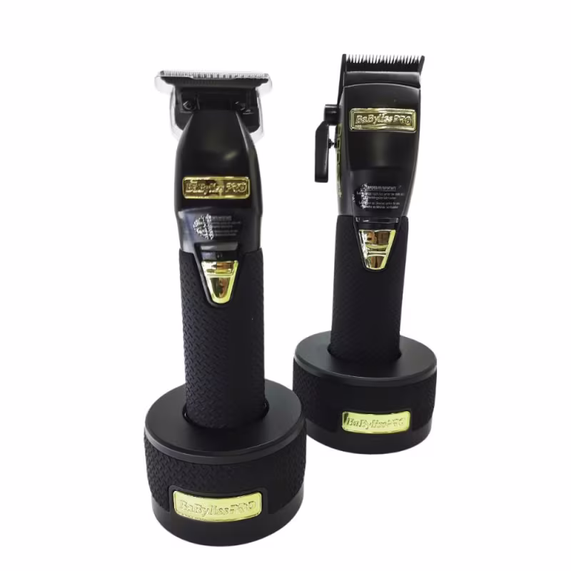 Estes são dois aparadores de cabelo profissionais da marca BaByliss Pro. As lâminas de corte são metálicas e expostas na parte superior. Há detalhes dourados brilhantes nas extremidades e no centro dos aparadores.