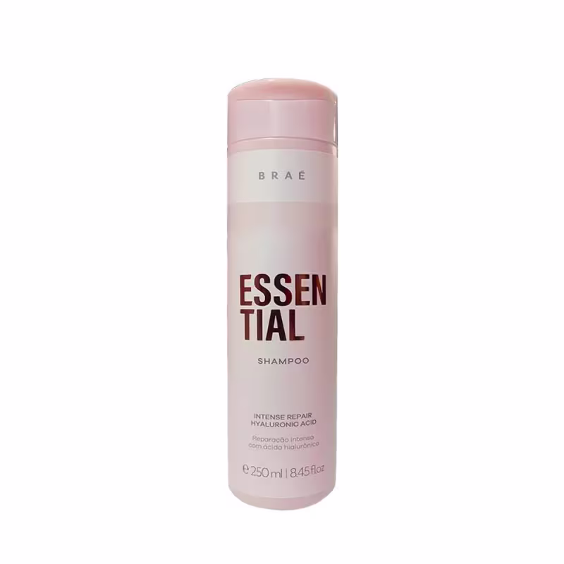Shampoo em embalagem cilíndrica plástica rosa e branca. Rótulo com o nome do produto "Essential" em letras grandes marrons e a marca "Brae" em letras menores acima.