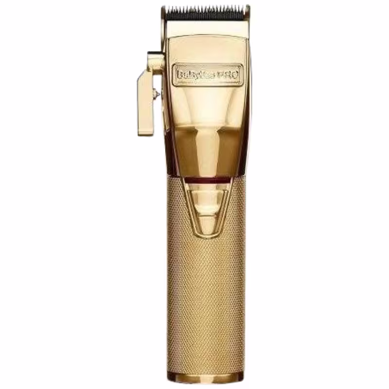 A imagem mostra a máquina de corte da BaByliss Pro na cor dourada. Possui um corpo metálico texturizado. A lâmina de corte aparece na parte superior, com dentes metálicos expostos. O logotipo "BaByliss Pro" está gravado no corpo do aparelho.