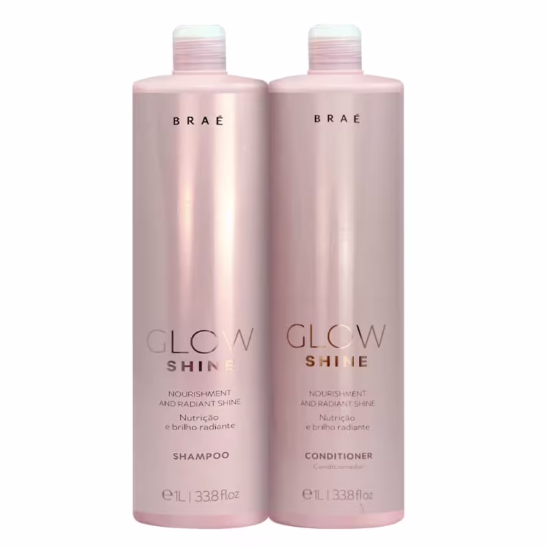 Conjunto de produtos para cabelos da marca Brae. Dois frascos grandes de plástico na cor rosa perolado, um contendo shampoo e o outro condicionador da linha "Glow Shine". Os frascos têm formato cilíndrico e tampas brancas com detalhes em listras.