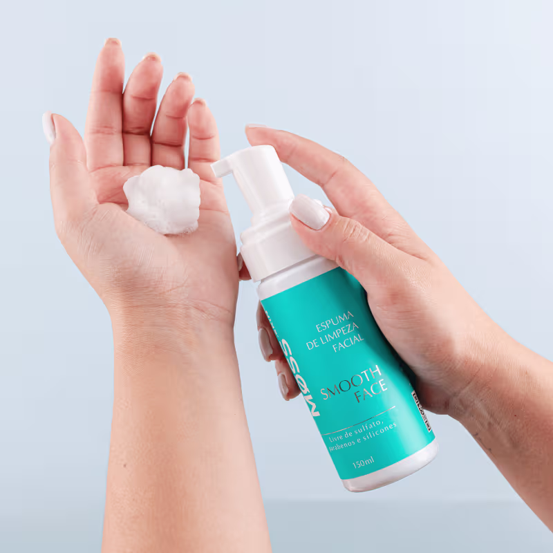 A imagem mostra uma mão branca feminina aplicando a espuma de limpeza em outra mão.