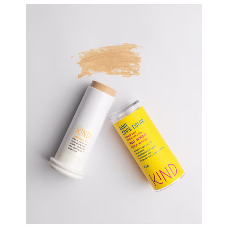 A imagem mostra o protetor solar aberto, com a embalagem do lado esquerdo e a tampa do lado direito, e, acima, uma amostra da cor e textura do produto. Tudo isso em fundo branco.