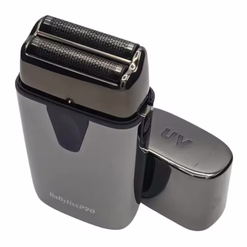 Este é um aparelho de barbear elétrico da marca BaByliss Pro. O aparelho de barbear é preto e possui uma cabeça de corte cromada com duas lâminas expostas. O design é compacto e minimalista, com linhas retas e acabamento brilhante.