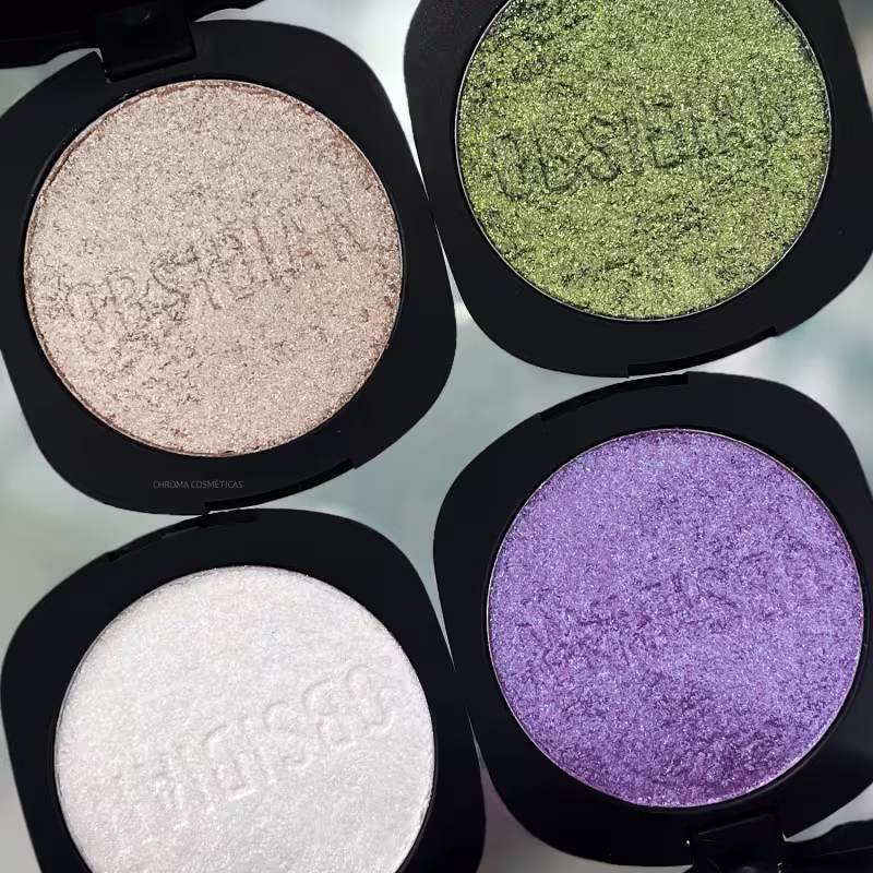 Sombra compacta de maquiagem em tom rosado perolado. Embalagem preta redonda com tampa protetora. Na parte interna, há o produto prensado com a inscrição "Obsidian" gravada.