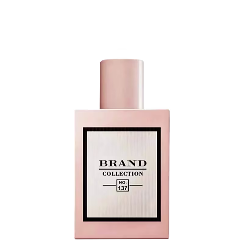 A imagem mostra um frasco do perfume Brand Collection NO 137. O frasco é de cor rosa claro e possui um design elegante e minimalista. Apresenta uma etiqueta em branco com a inscrição "BRAND COLLECTION No. 137" em letras pretas.